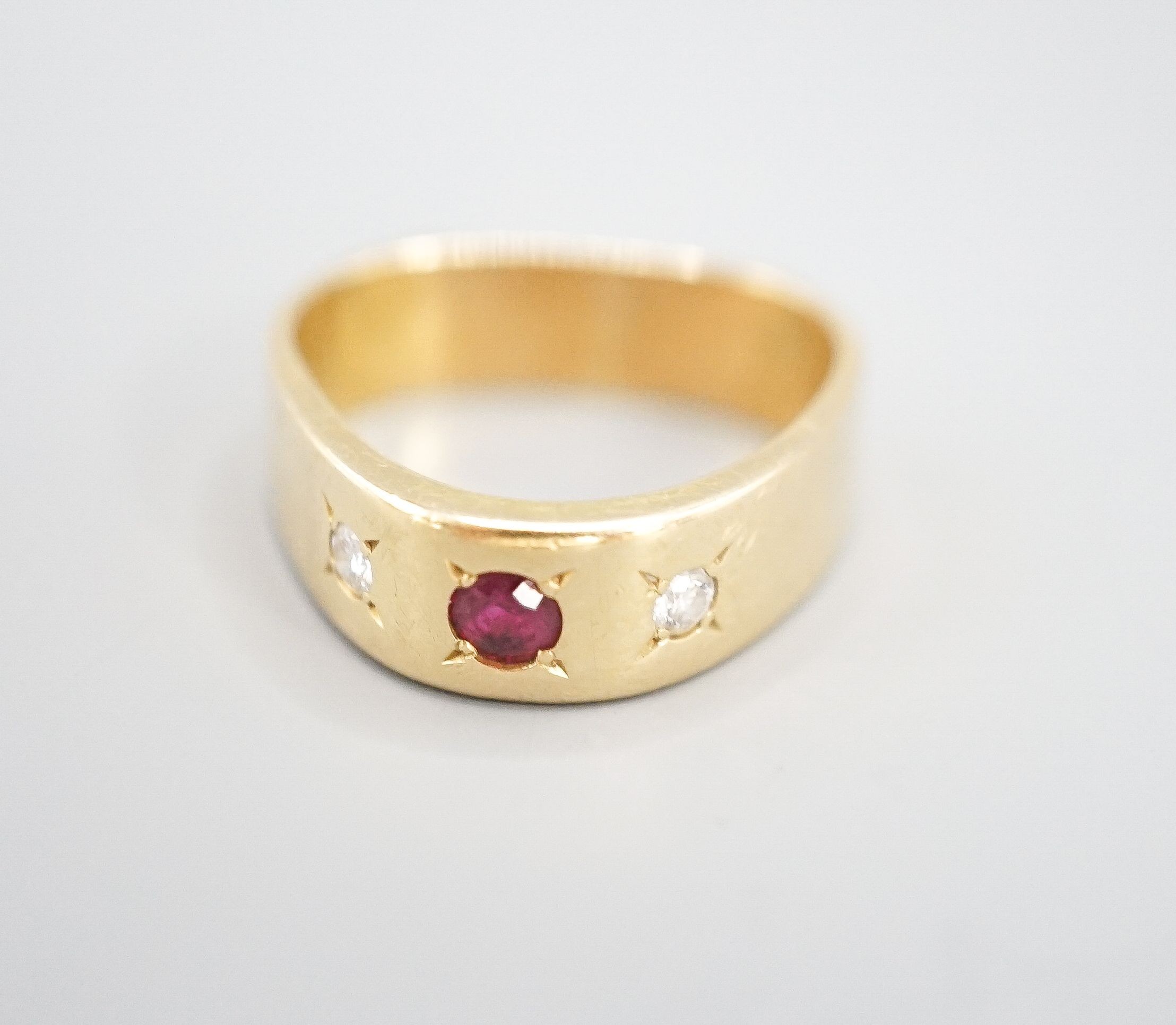 An 18ct and gypsy set three stone ruby and diamond ring, of triangular form, size O/P